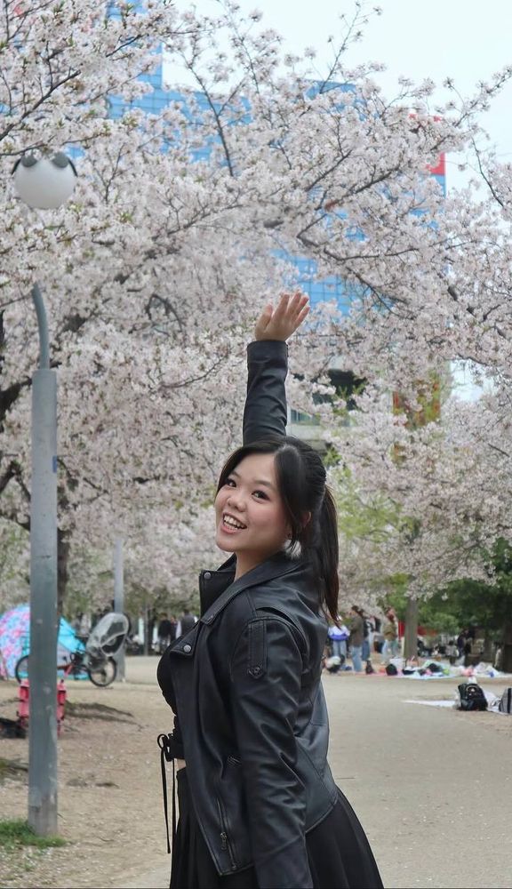 Chloe smiling beneath cherry blossoms